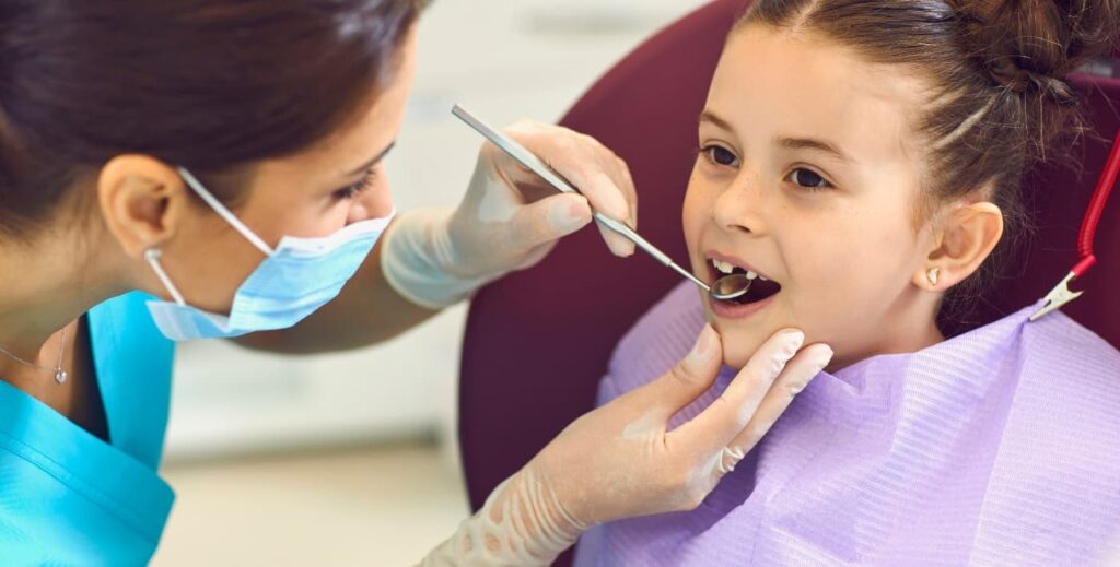 Niña en revisión en el dentista.