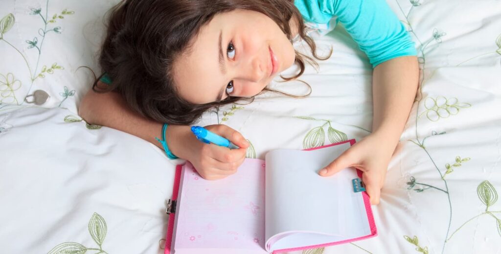 Niña escribiendo su diario.